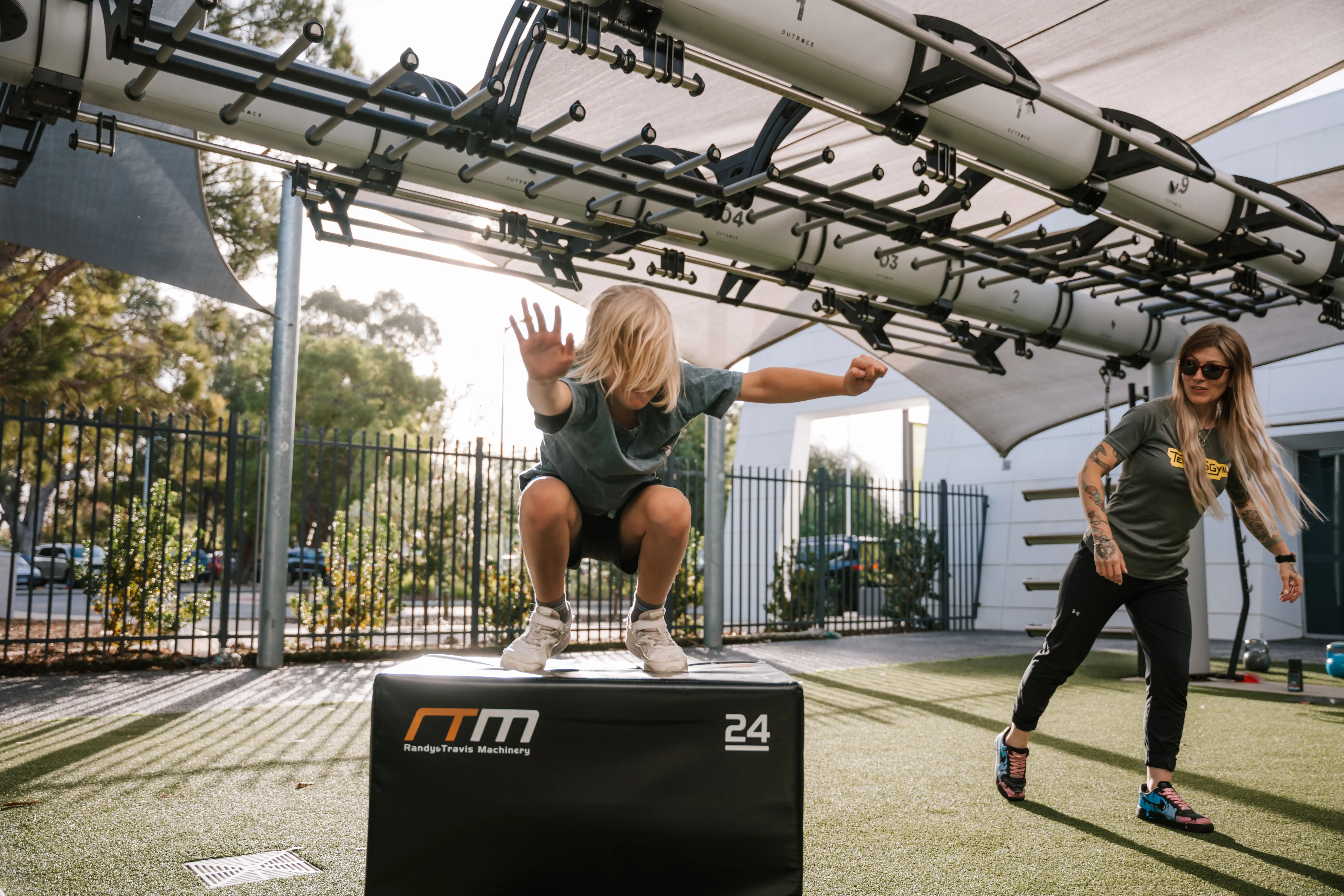 Child jumping onto box in exercise class.